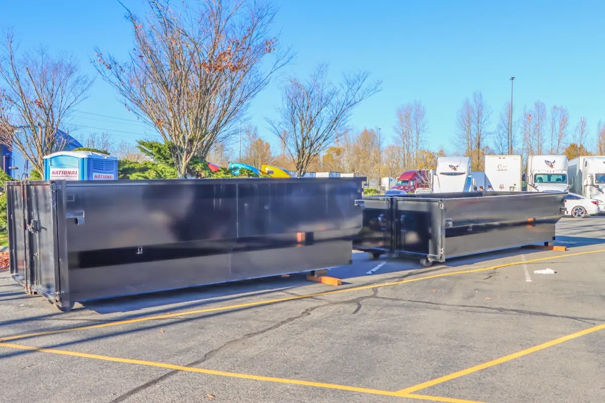 Professional dumpster rental service with roll-off container on residential driveway in Opp